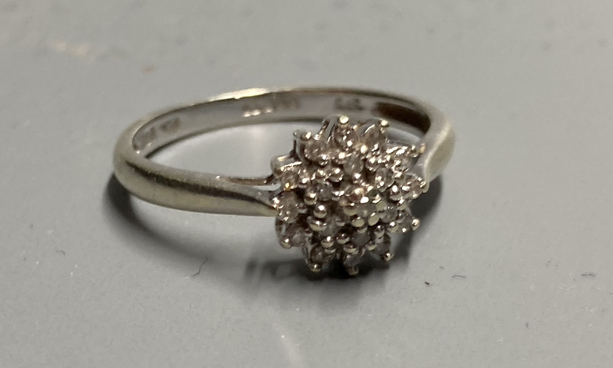 A modern 9ct white gold and diamond cluster ring, size M/N, gross 2 grams.